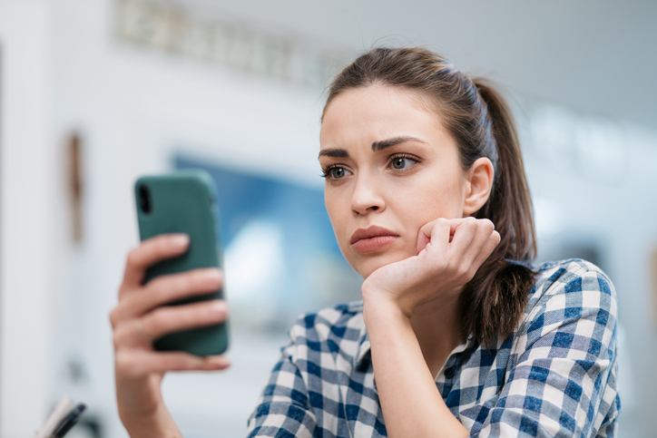 Sad women looking at cell phone 