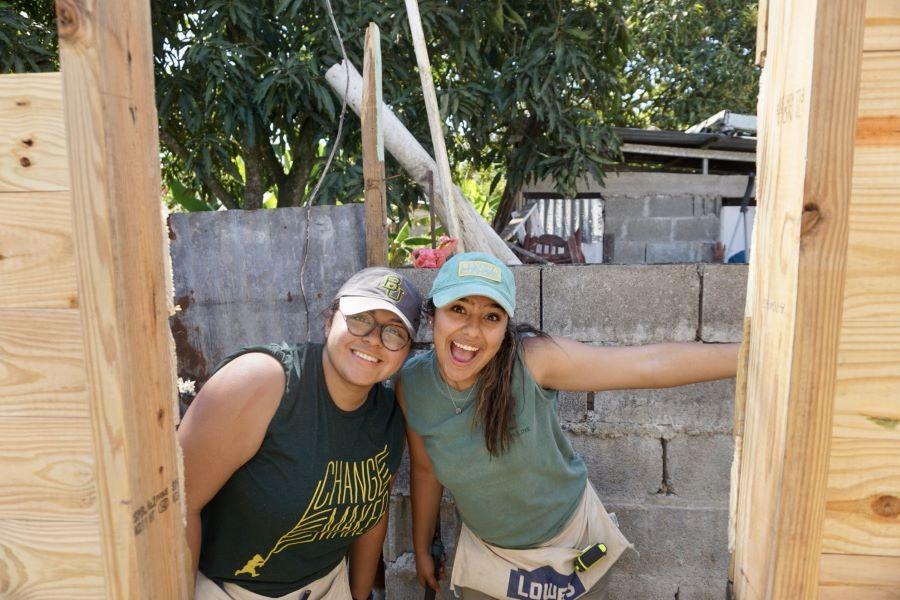Baylor students in t-shirts and toolbelts build a house in the Dominican Republic