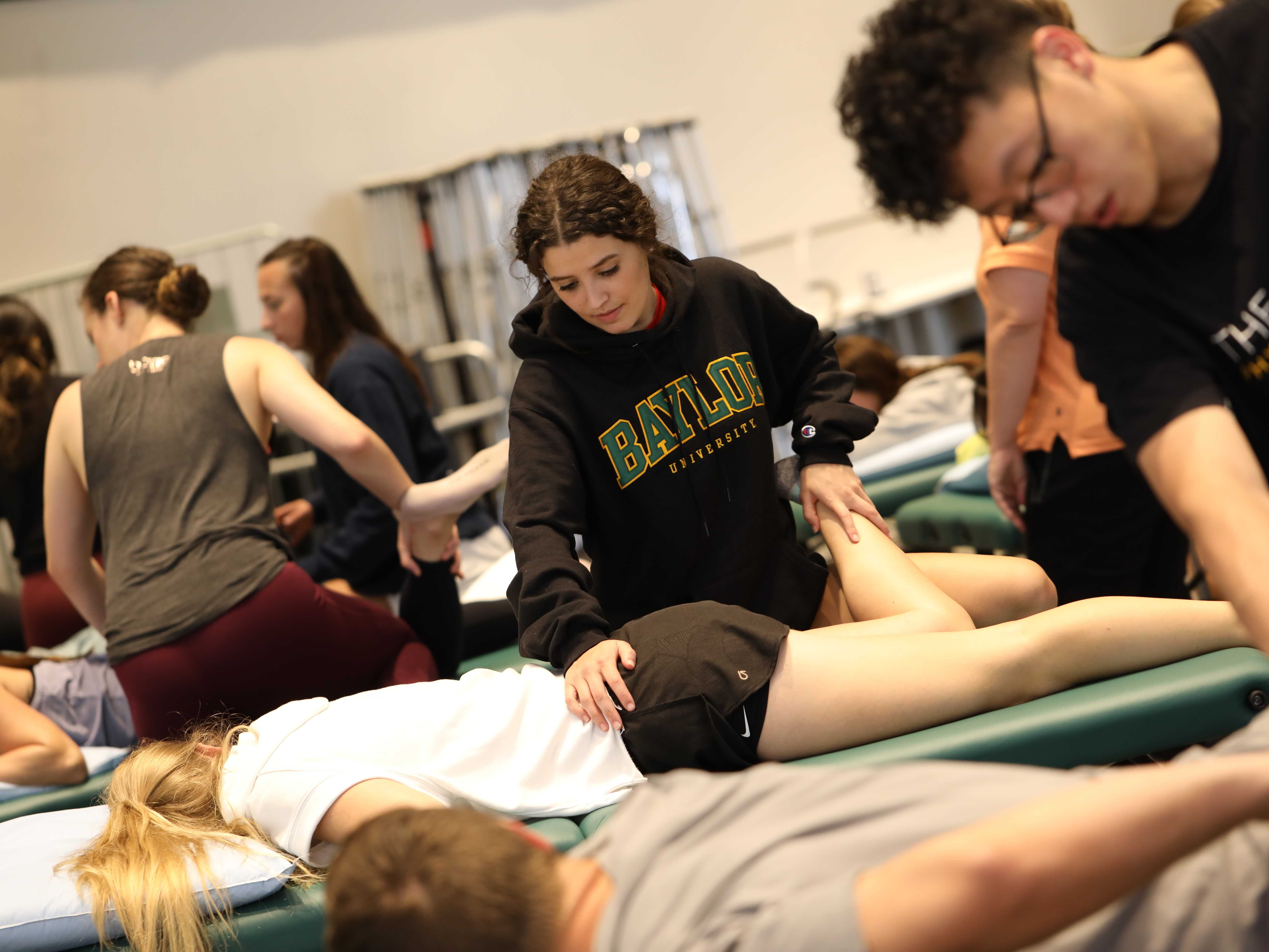 Baylor Physical and Occupational Therapy graduate students practicing their skill in an on-campus lab immersion session.
