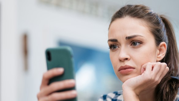 Sad woman looking at cell phone