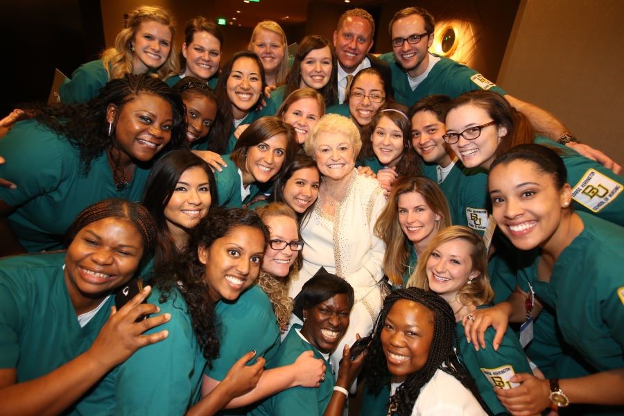 Louise Herrington Ornelas is surrounded by a smiling group of Baylor Nursing students
