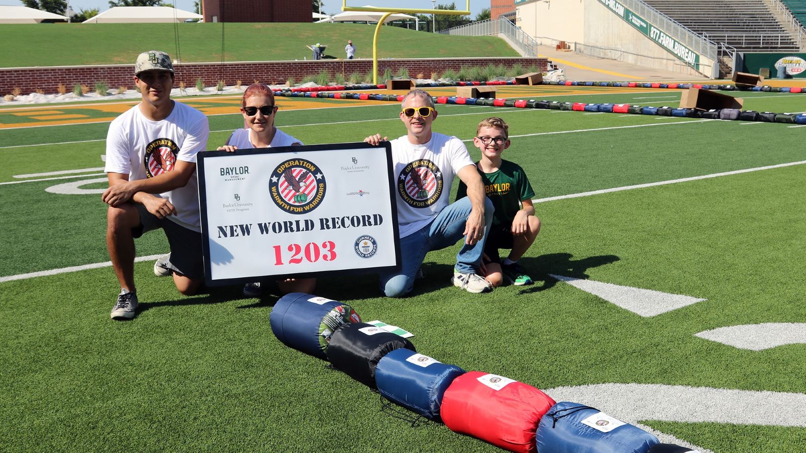 Baylor School of Education students pose with lined up sleeping bags and a world record sign