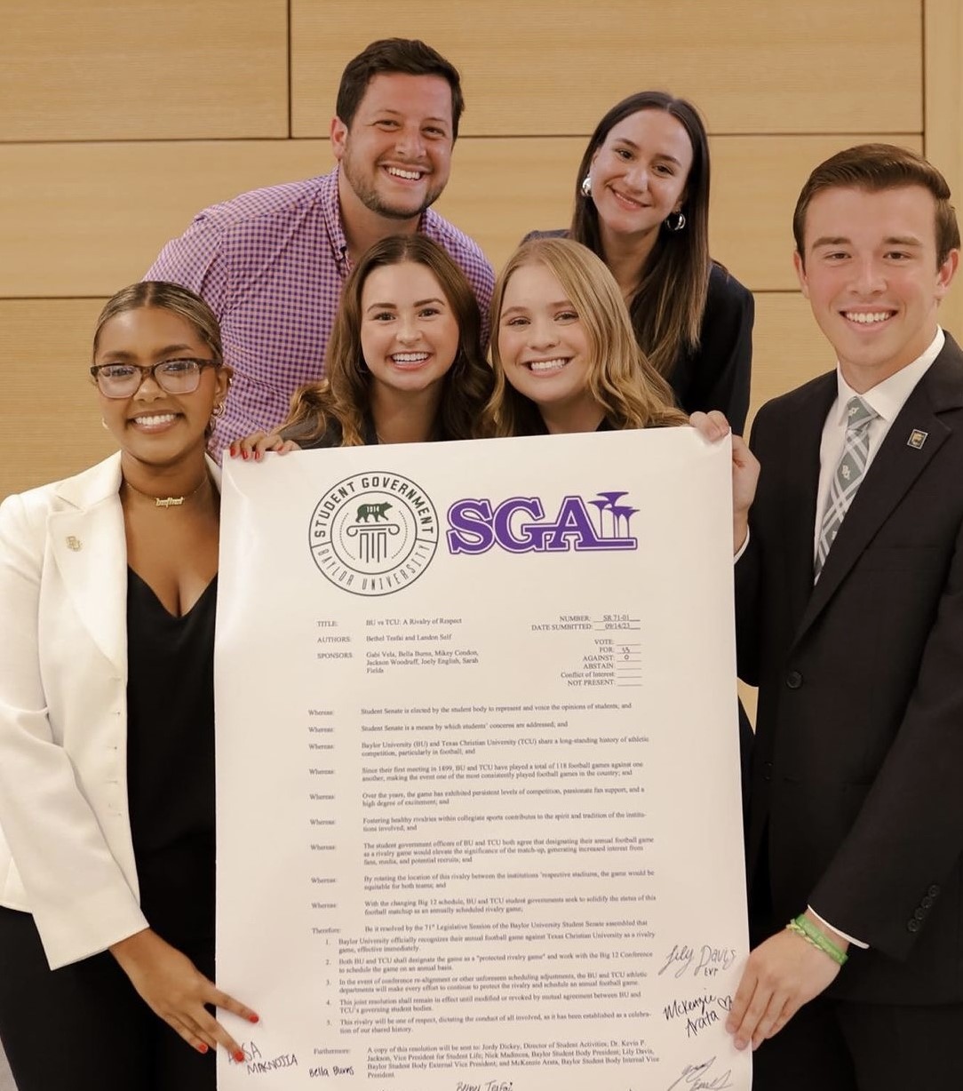 Members of Baylor and TCU student government hold a copy of their legislation to name Baylor-TCU rivalry as The Bluebonnet Battle