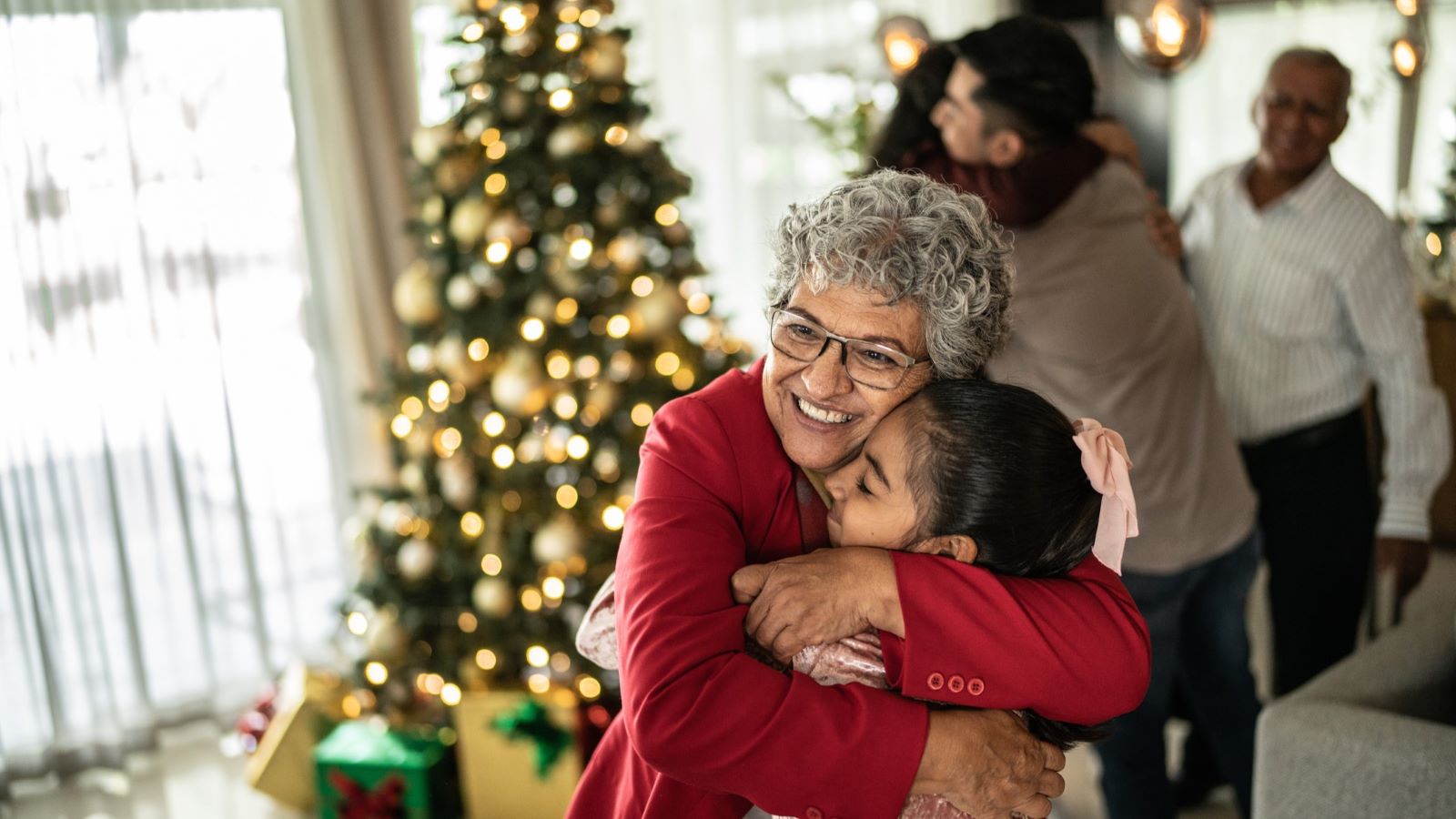 Grandmother hugging her granddaughter on Christmas at home