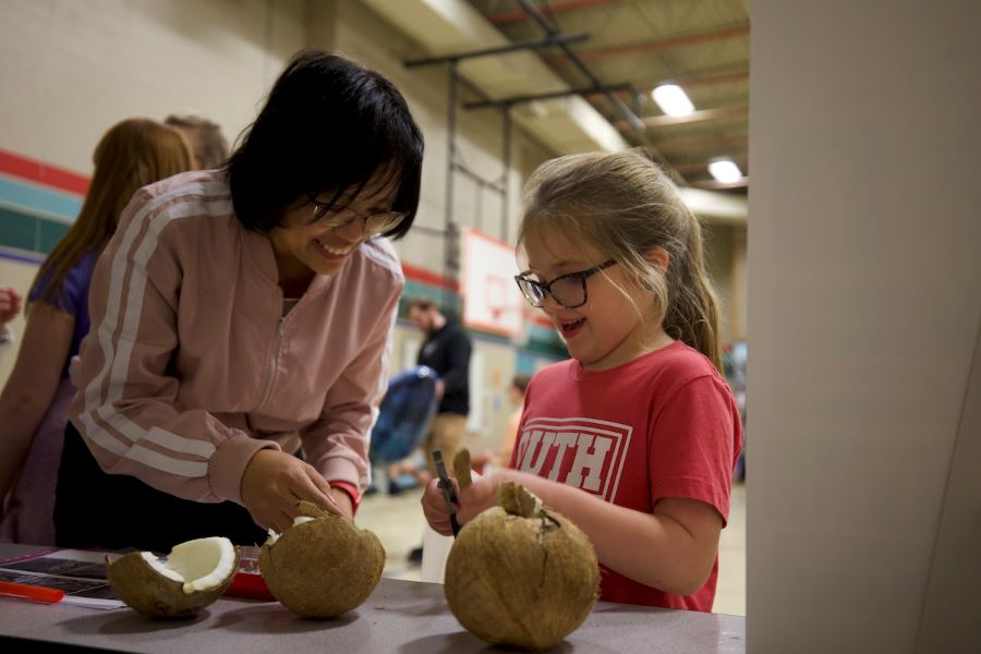 Baylor mechanical engineering professor Ning Zhang assists elementary school students with putting together catapults made of popsicle sticks and rubber bands.