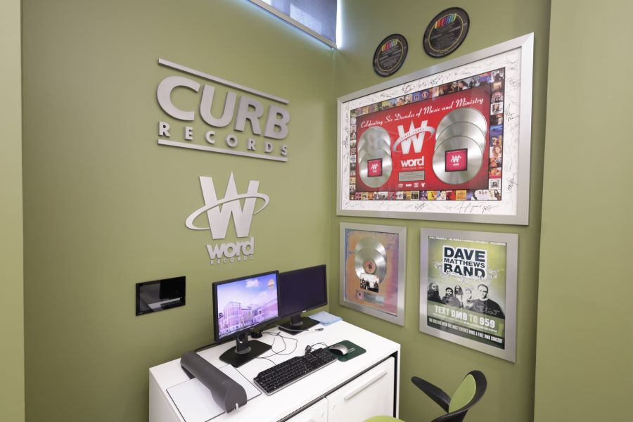 Wall of photos and platinum records illustrates the Baylor ties within Curb | Word Entertainment