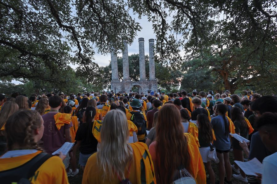 Crowd of students in gold Baylor Line jerseys gather before the four columns in Independence, Texas