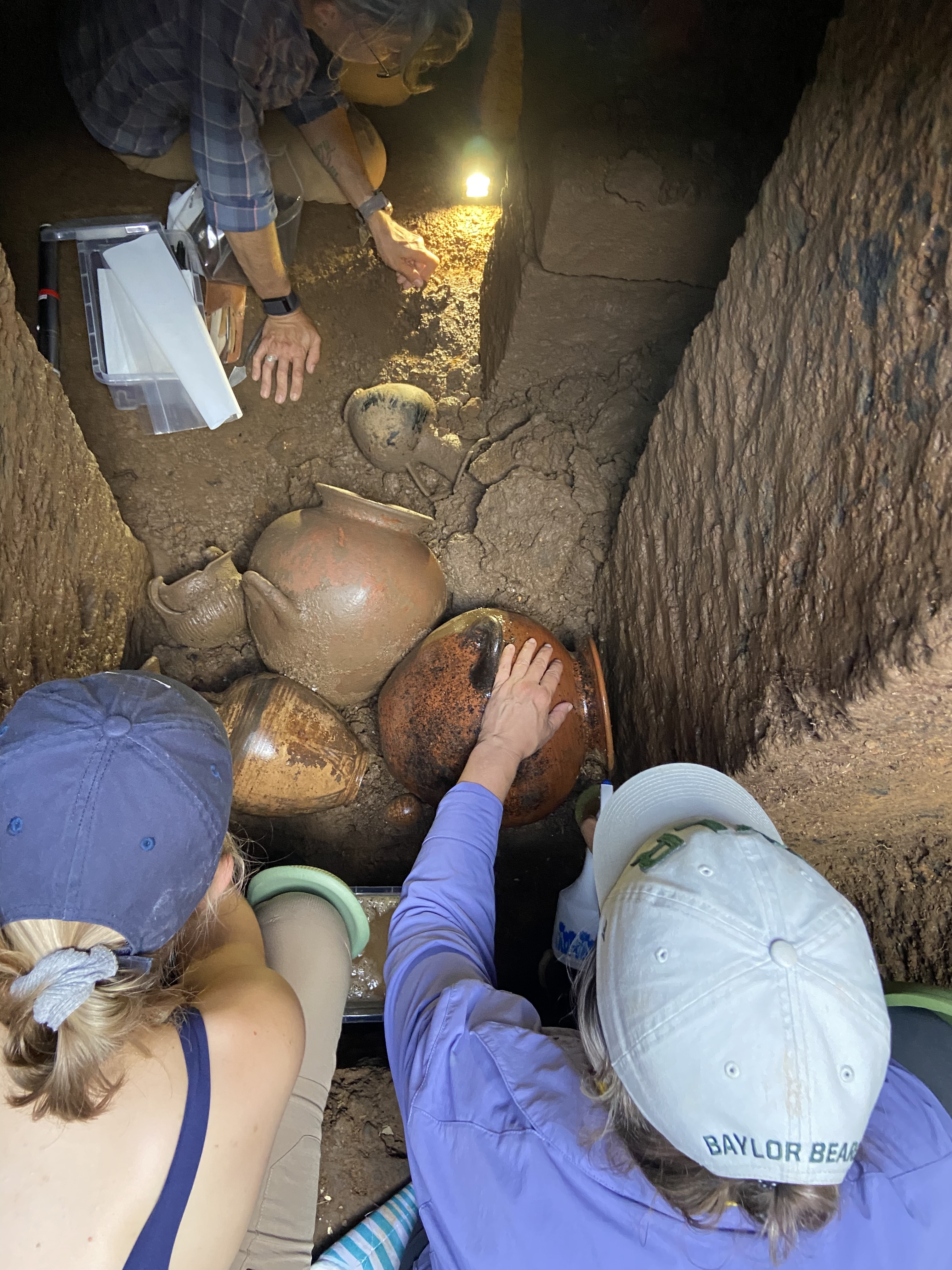 researchers recovering pottery from 7th century BC Etruscan tomb