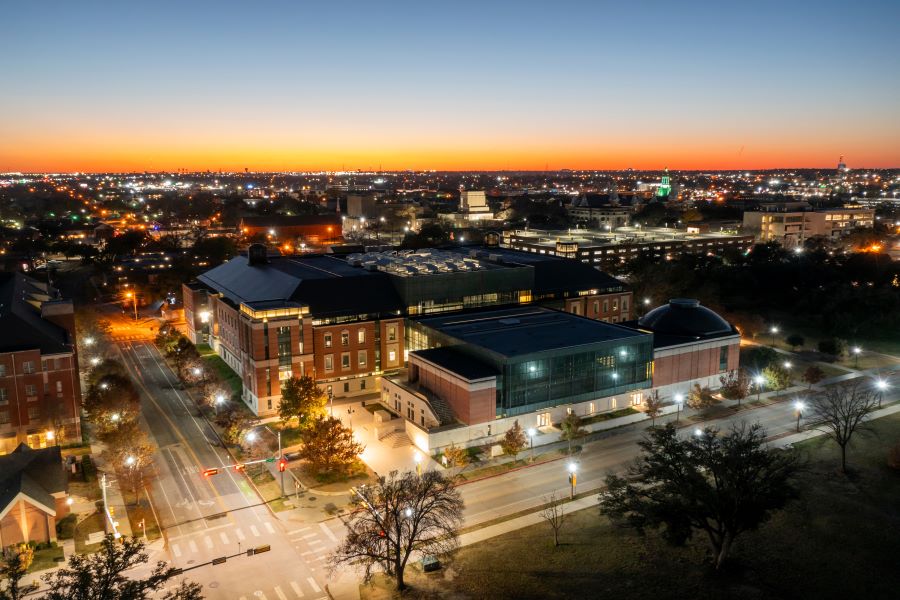 Aerial view as the sun sets over Baylor University's red brick business school