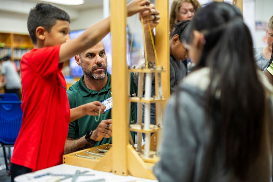 Geology professor leads elementary school students in a science experiment that simulates earthquakes.