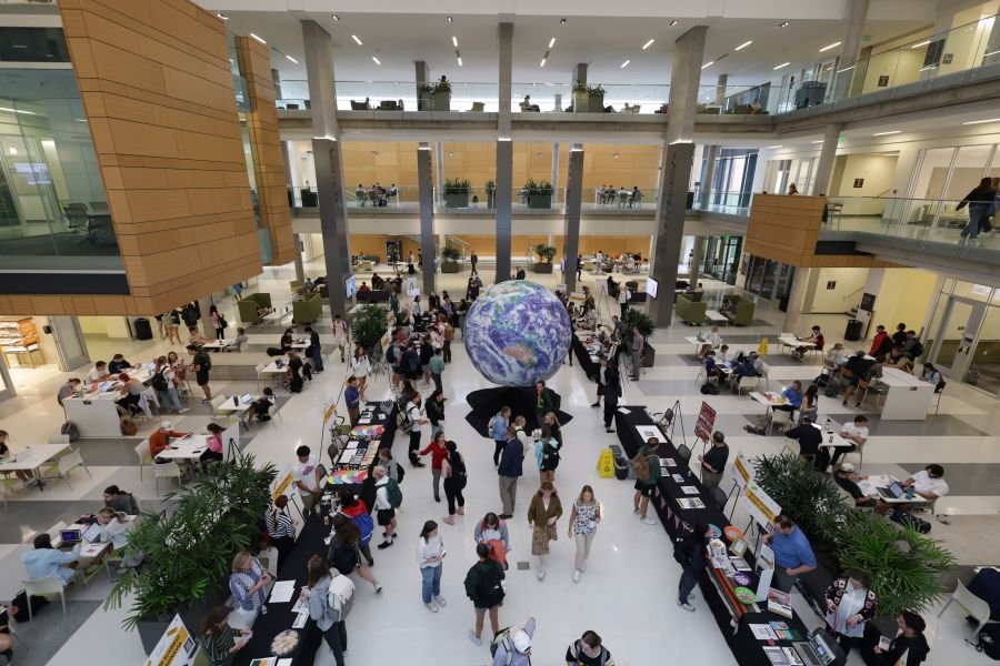 Students and faculty discuss global study and internship opportunities at an event in the atrium of the Hankamer School of Business.