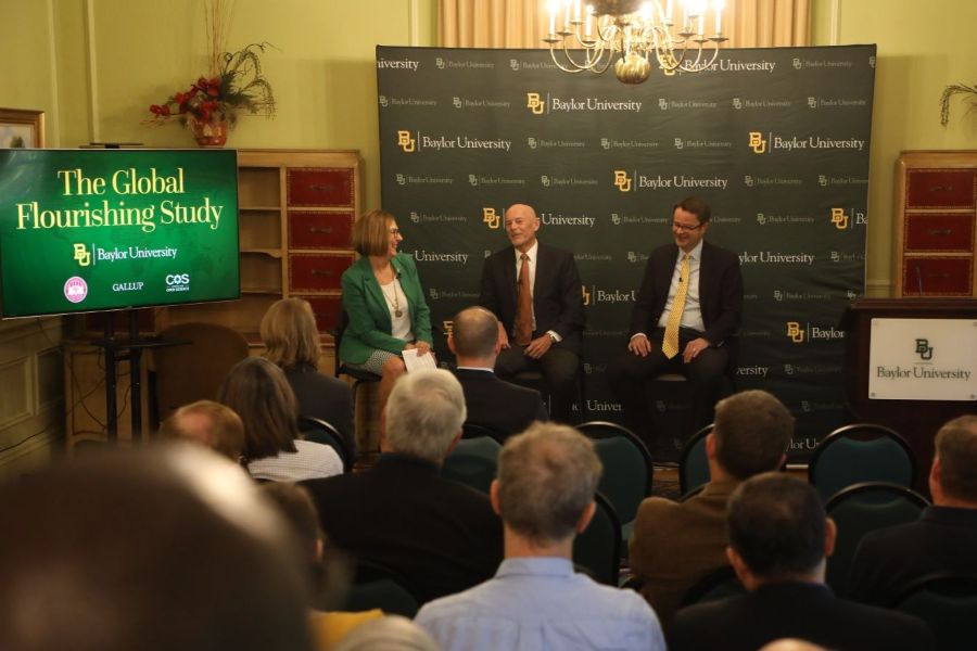 Three Baylor faculty on a Baylor University stage for a presentation announcing the Global Flourishing Study