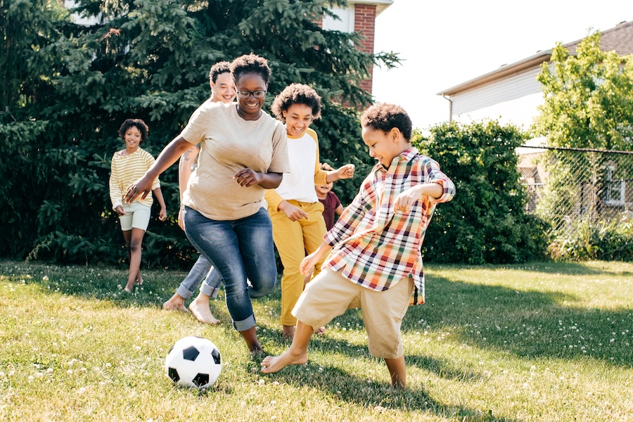 Family playing with soccer ball outside