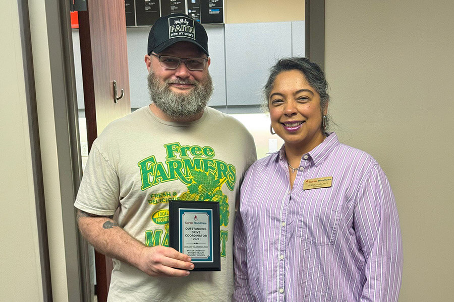 A man receives and award presented by a woman