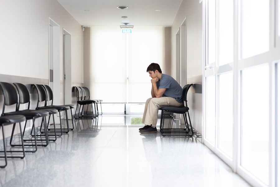 Male teenager in the waiting room of a medical clinic - stock photo