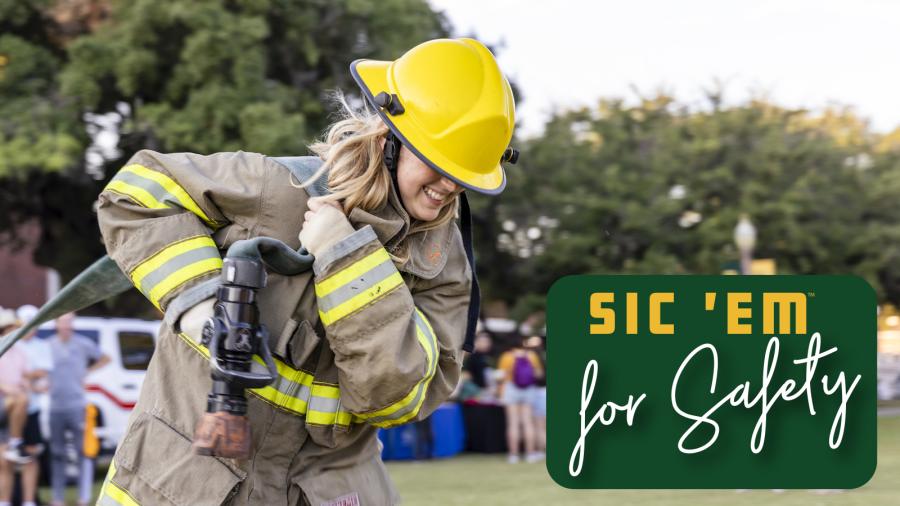 Student tries on firefighter uniform during Sic 'em for Safety event 