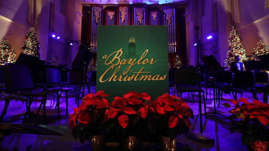 A Baylor Christmas performance stage with red poinsettias