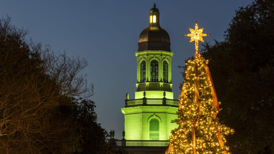 Pat Neff Hall tower is lit green with Christmas Tree in foreground