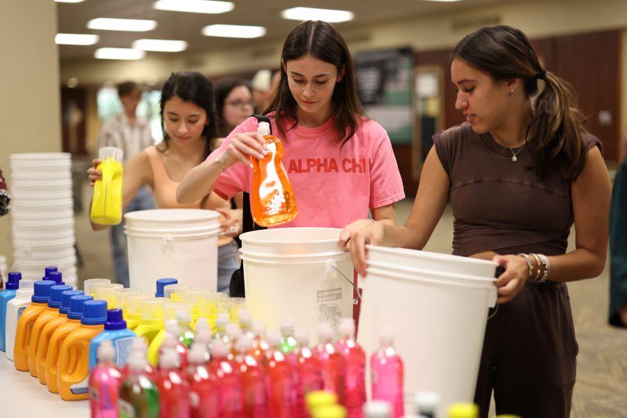 Baylor students pick up supplies on tables to pack into disaster relief kits.