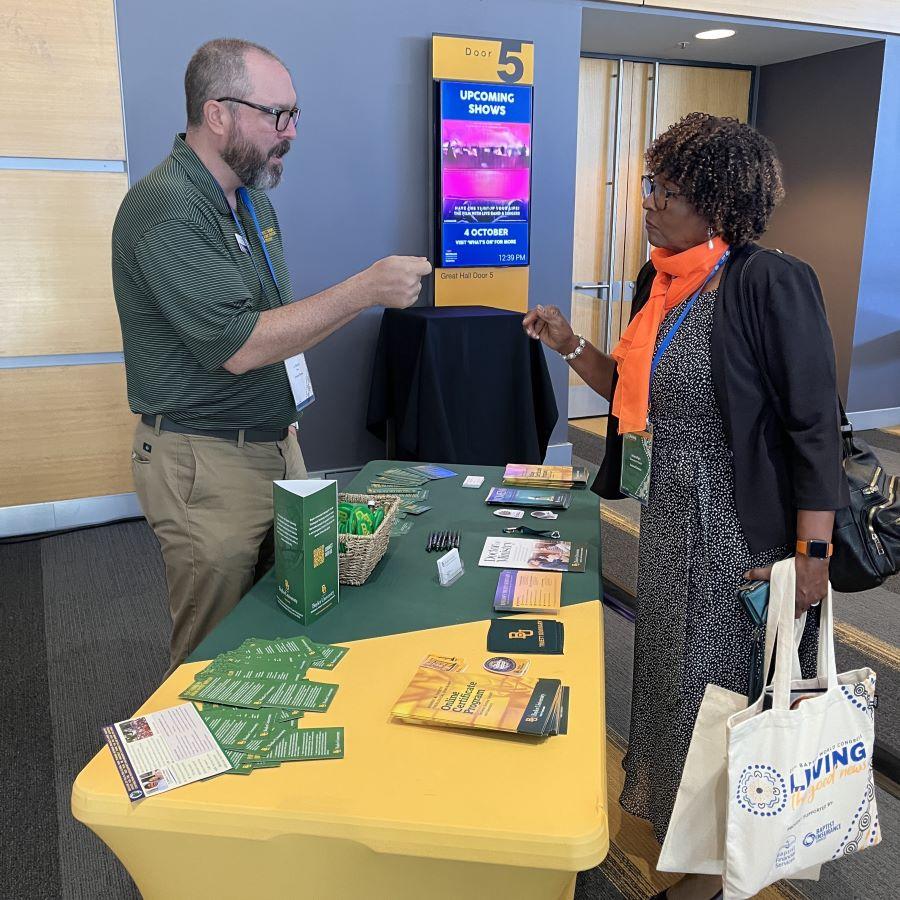 J. David Tate, Director of the Online Certificate Program at Baylor's Truett Seminary, talks with a woman interested in the program