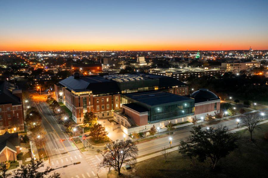 Aerial view as the sun sets over Baylor University's red brick business school