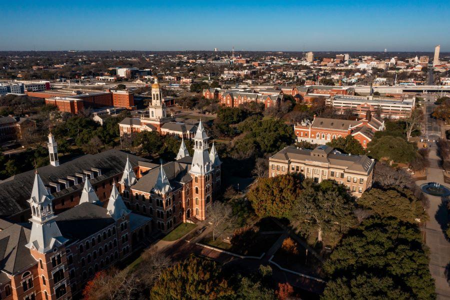 Red brick buildings with spires and a blue skyline