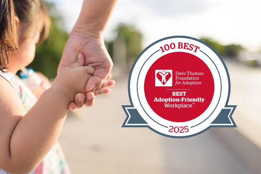 close up of a small girl holding an adult's hand with the 100 Best Adoption-Friendly Workplace 2025 badge. 