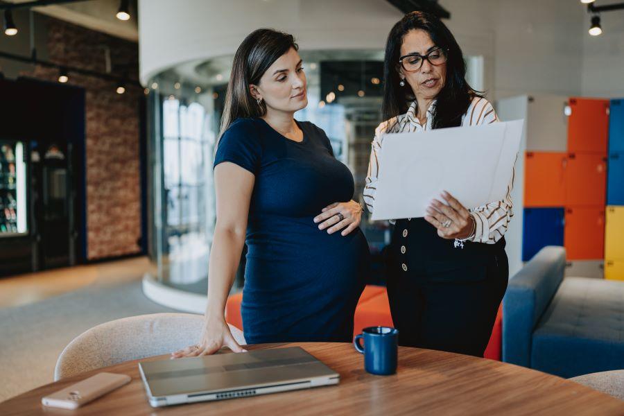 2 women stand and look at a file