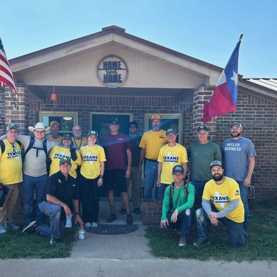 Group of volunteers from Baylor University and Texans on Mission stand in front of a home they helped repair after it was damaged in summer floods in San Angelo.
