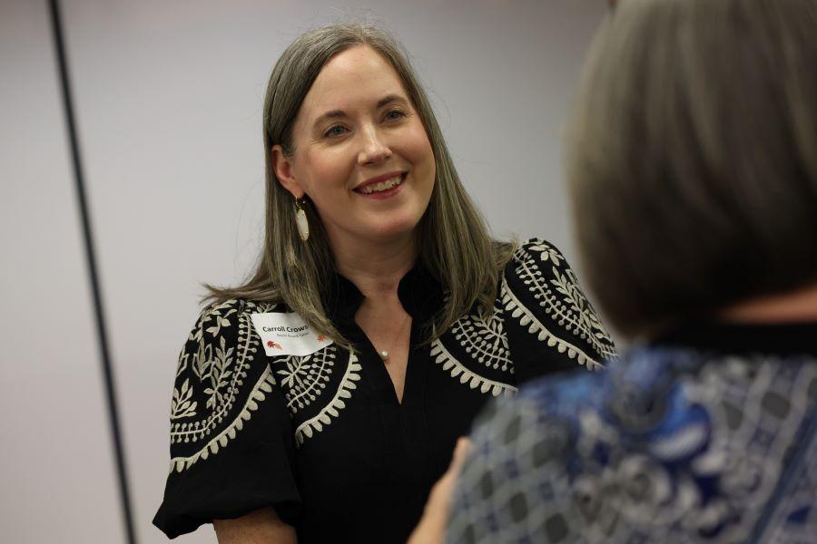Smiling woman in a black and white patterned blouse