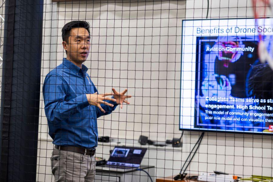 Professor in a long-sleeved blue shirt discussing drones in an engineering class
