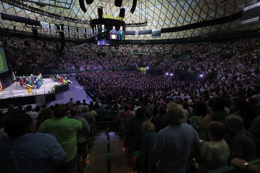 University commencement service in a big basketball area with a full crowd
