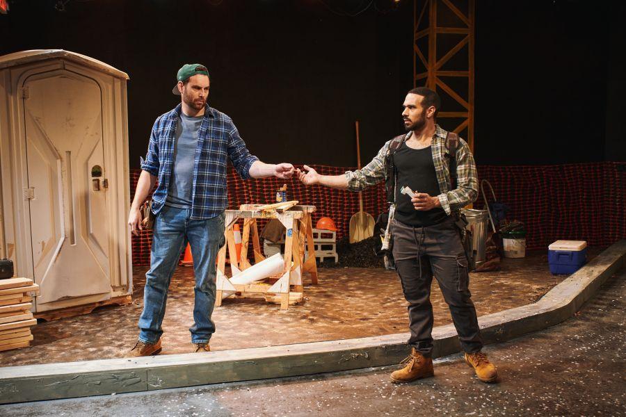 Two actors performing as construction workers in a stage play called "& Sons."