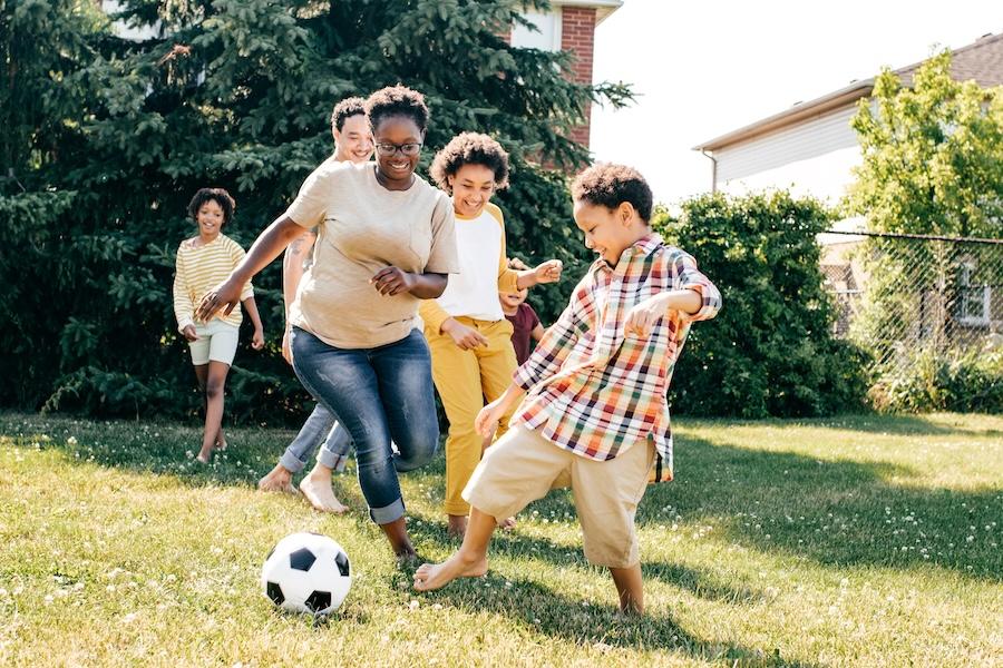 family playing outside with soccer ball