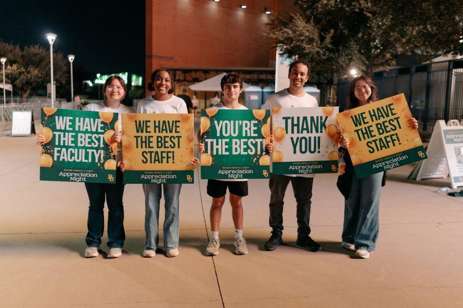Five Baylor University students hold signs expressing appreciation to Baylor employees on Faculty and Staff Appreciation Night.