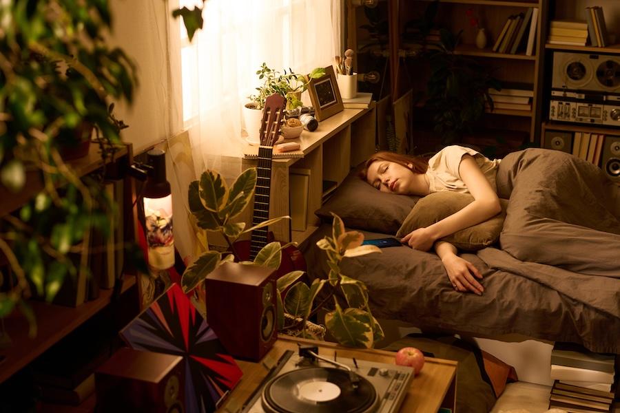 college student sleeping soundly in her dorm room while a fun vibe plays on the vinyl